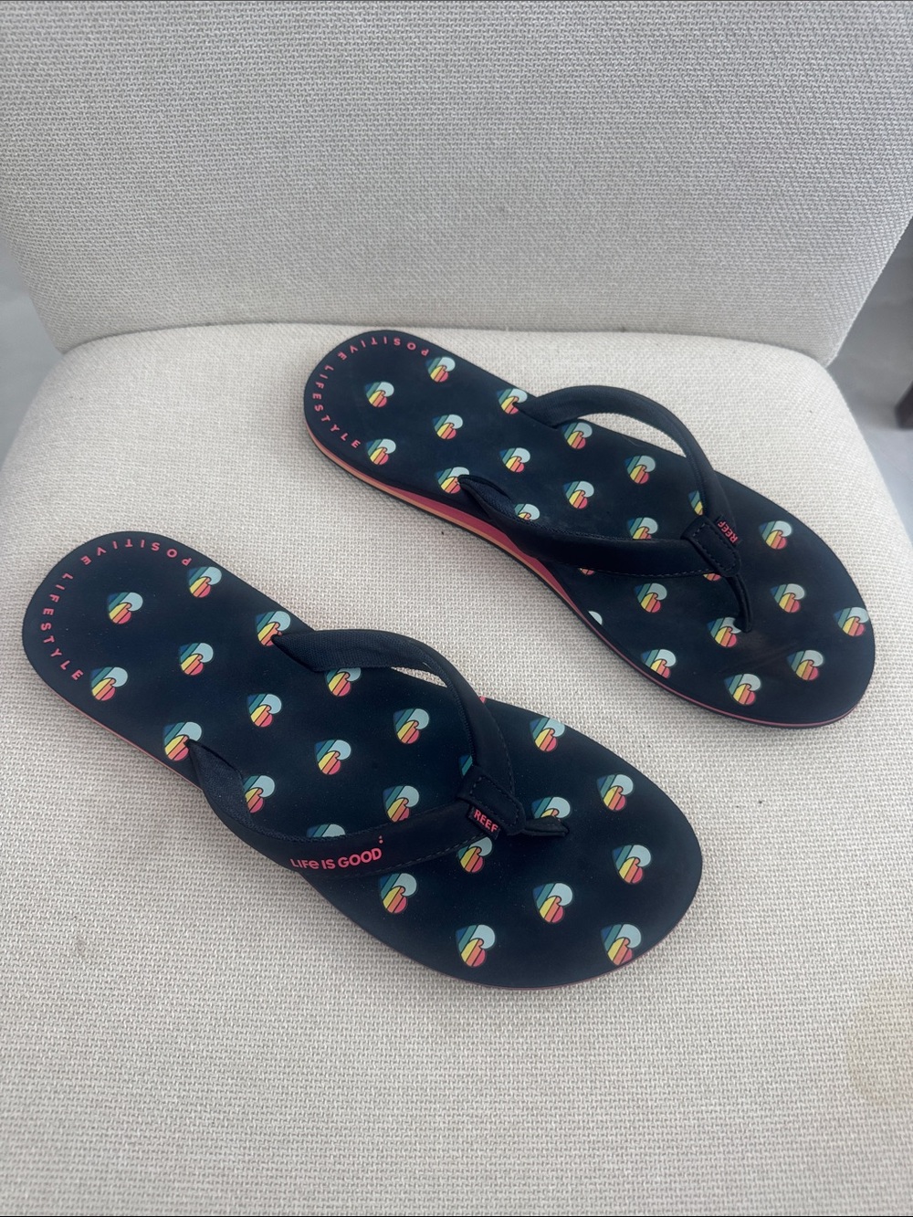 NWOT Reef “Life Is Good” Black Flip Flops with Multicolor Heart Pattern